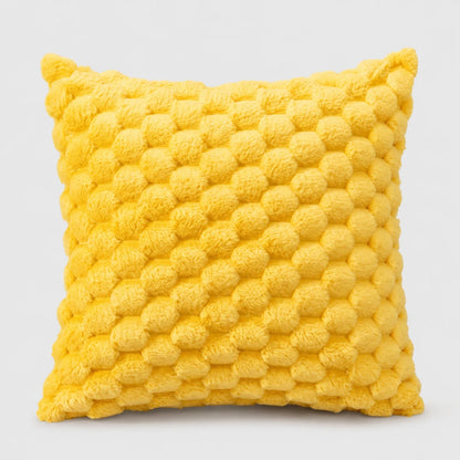 Josh & Tate - PuffKnot™ Bobble Cushion Cover - A square yellow throw pillow with a textured, raised pom-pom or bumpy knit pattern, shown against a plain light gray background.