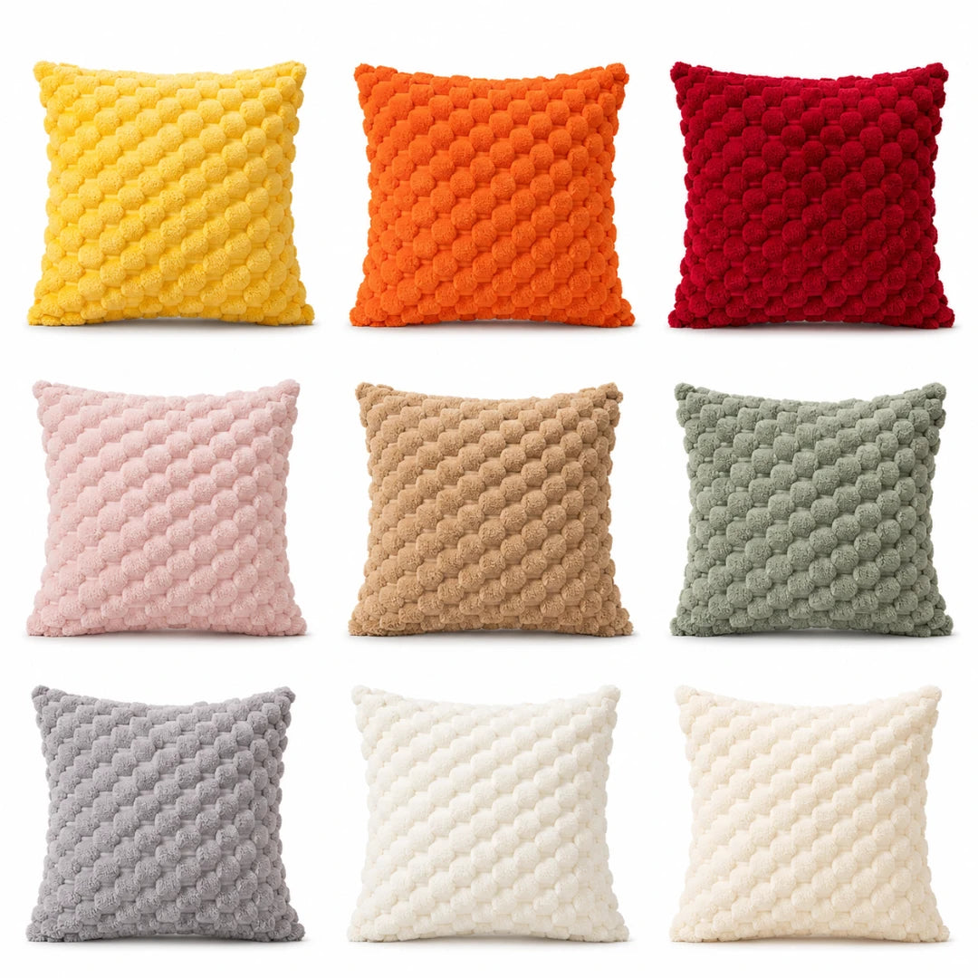 Josh & Tate - PuffKnot™ Bobble Cushion Cover - Nine square throw pillows arranged in a 3-by-3 grid on a white background, each in a different color: yellow, orange, red, pink, tan, sage green, gray, off-white, and cream. The pillows have a chunky, textured bobble or chenille surface.