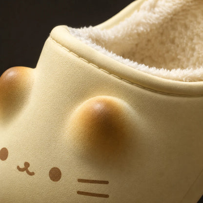 Josh & Tate - PurrPad™ Cozy Cat-Face Slippers - Close-up of a cream-colored slipper with a soft plush lining and a cute cat face design, featuring raised cheeks and simple facial features.