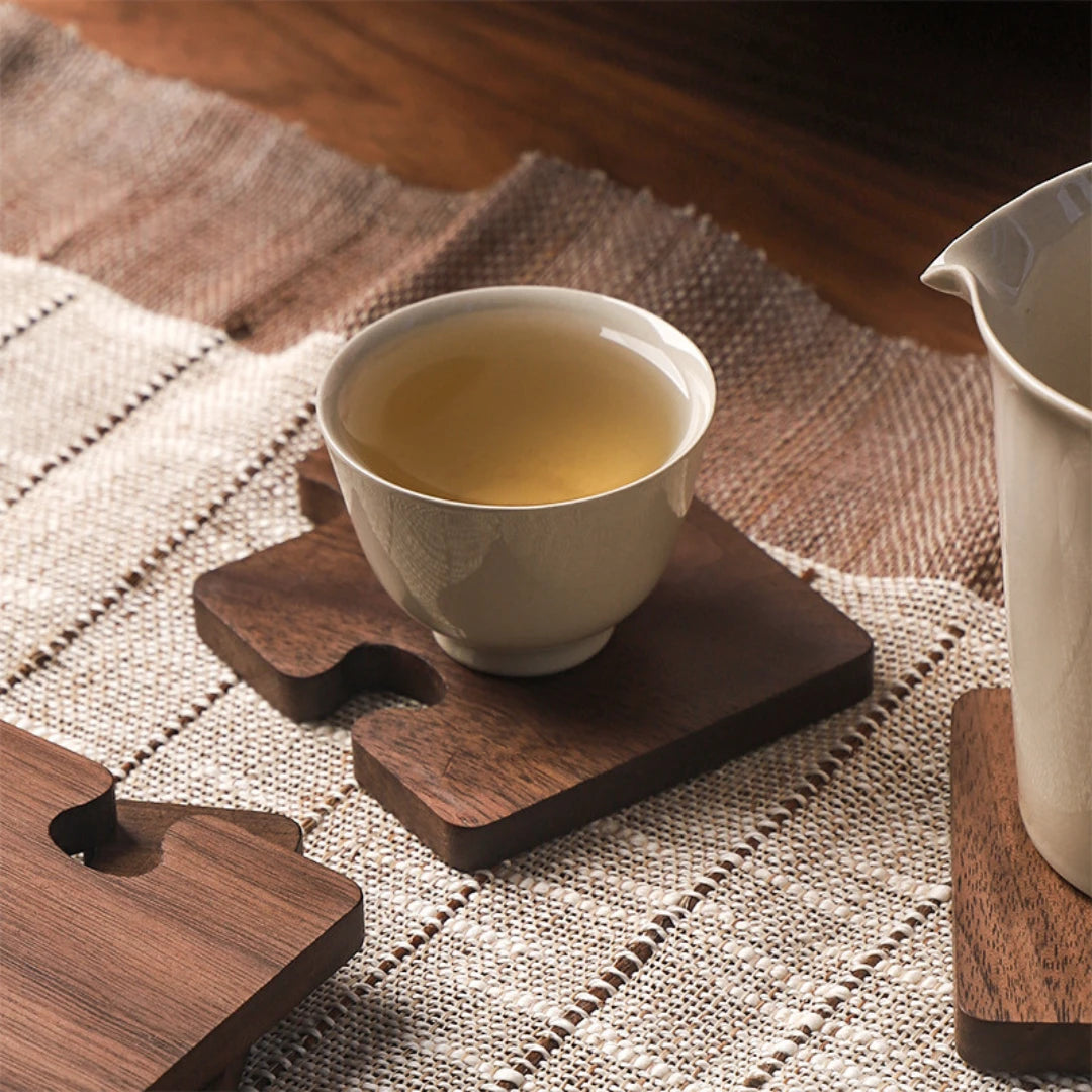 Josh & Tate - PuzzleDeck™ Wood Jigsaw Coasters - Tea cup on a wooden coaster with a woven mat background