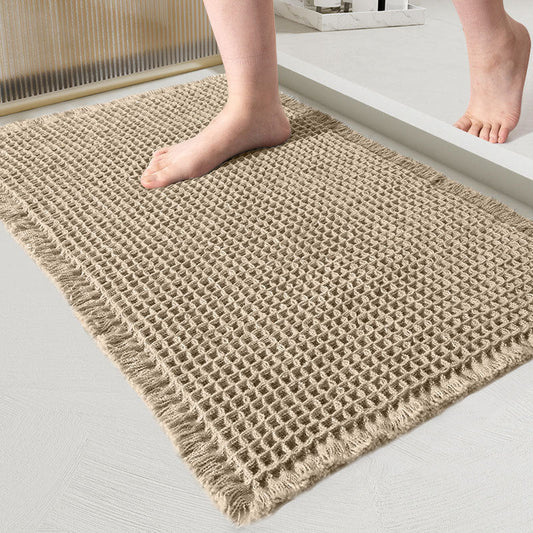 Beige woven mat on a light gray floor with feet stepping onto it.
