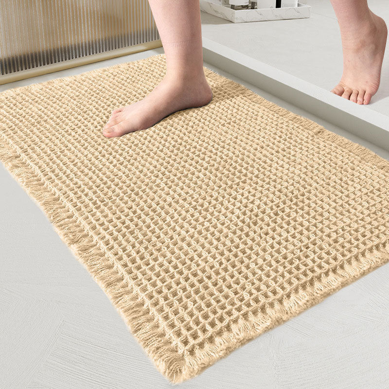 Beige woven mat on a light gray floor with feet stepping onto it.