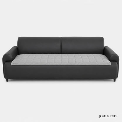 Josh & Tate - QuiltDrape™ Corduroy Sofa Cover - Black sofa with a gray quilted cushion on a white background, branded 'Josh & Tate'.