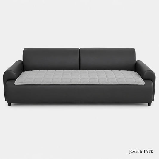 Josh & Tate - QuiltDrape™ Corduroy Sofa Cover - Black sofa with a gray quilted cushion on a white background, branded 'Josh & Tate'.