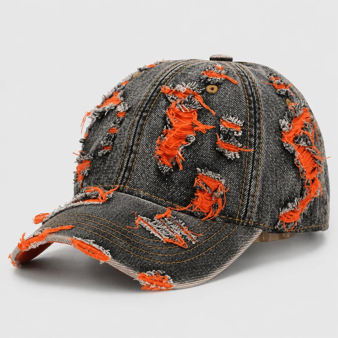 Josh & Tate - RaggedRow™ Distressed Denim Cap - A distressed baseball cap made of dark gray denim with bright orange frayed thread details throughout, shown on a light gray background.