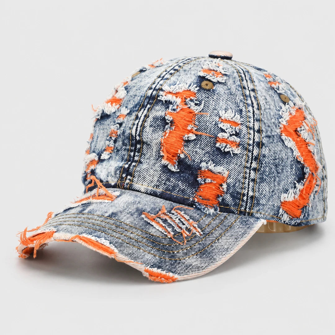 Josh & Tate - RaggedRow™ Distressed Denim Cap - A distressed denim baseball cap with heavy orange frayed detailing and ripped details, shown on a light gray background.
