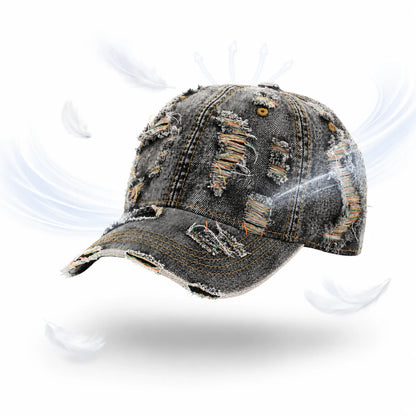 Josh & Tate - RaggedRow™ Distressed Denim Cap - A distressed denim baseball cap with ripped details and frayed edges, shown floating on a white background with feather graphics and light swirls.