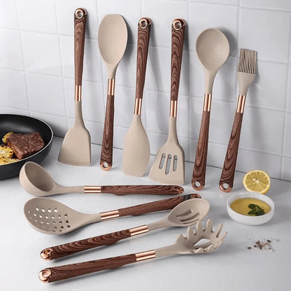 Set of kitchen utensils with wooden and rose gold handles on a kitchen counter.