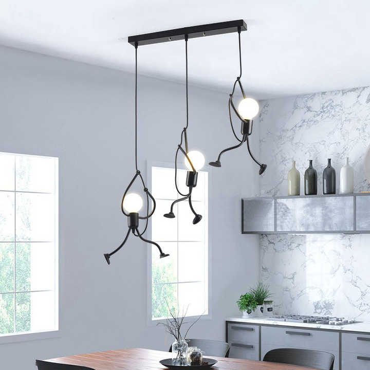 Modern pendant lights hanging above a kitchen table with a marble backsplash.