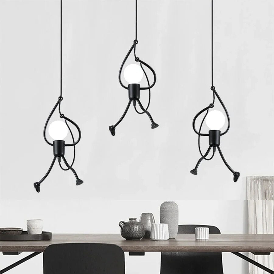 Three modern pendant lights hanging above a dining table with a neutral background