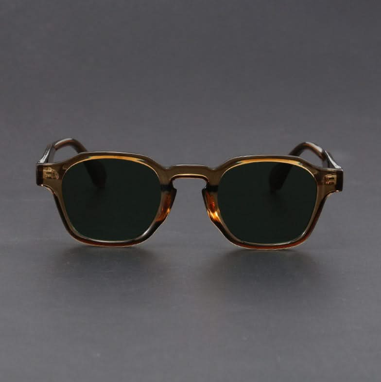 Sunglasses with a gold frame and dark lenses on a gray background
