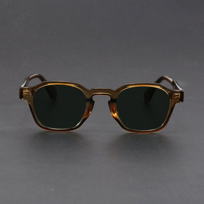 Sunglasses with a gold frame and dark lenses on a gray background