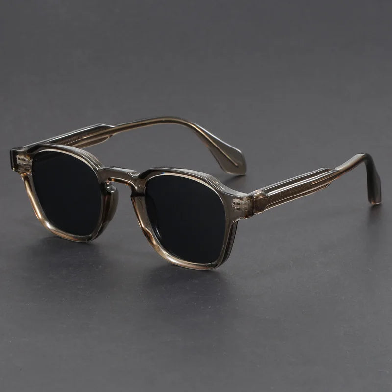Sunglasses with a dark gradient lens on a gray background