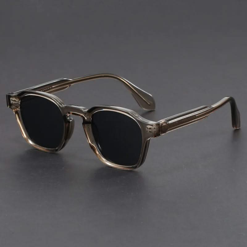Sunglasses with a dark gradient lens on a gray background