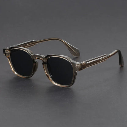 Sunglasses with a dark gradient lens on a gray background
