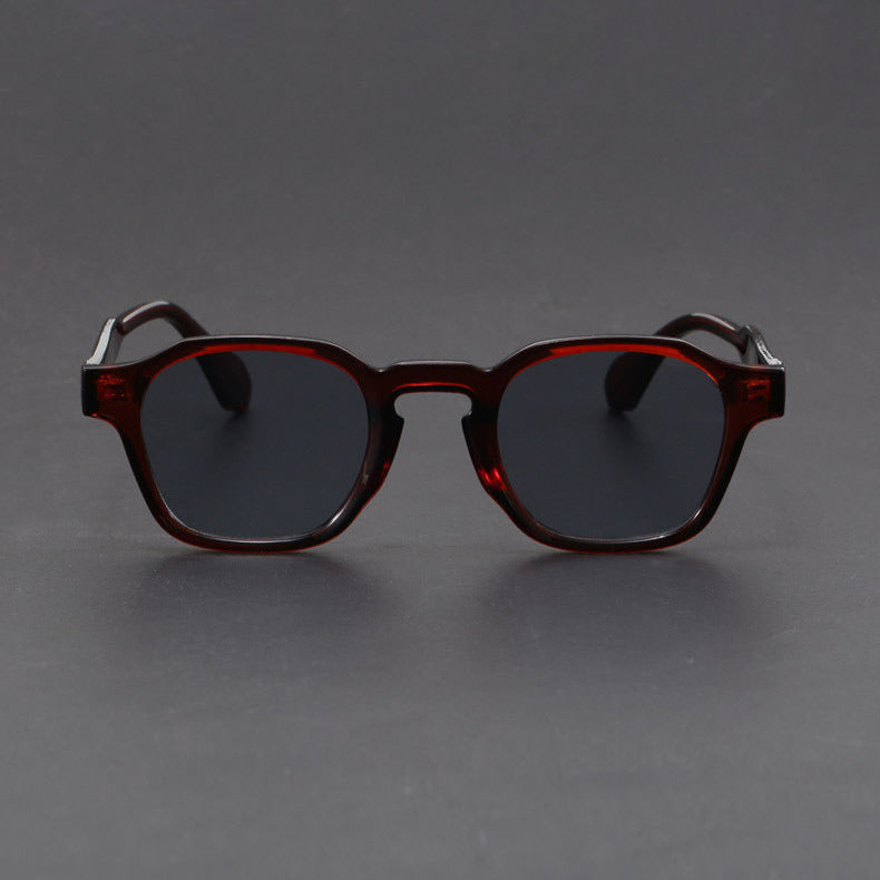 Sunglasses with dark lenses and brown frame on a gray background