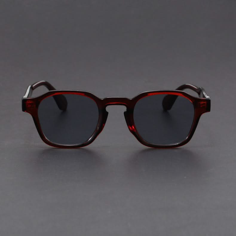 Sunglasses with dark lenses and brown frame on a gray background