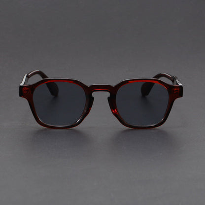 Sunglasses with dark lenses and brown frame on a gray background