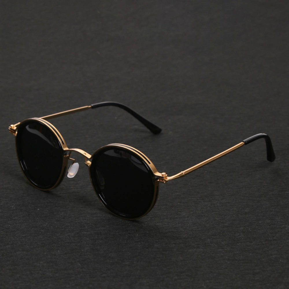 Sunglasses with gold frame and black lenses on a dark gray background