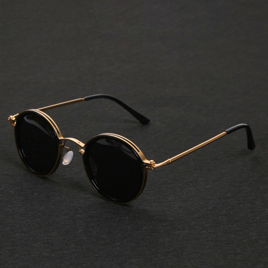 Sunglasses with gold frame and black lenses on a dark gray background