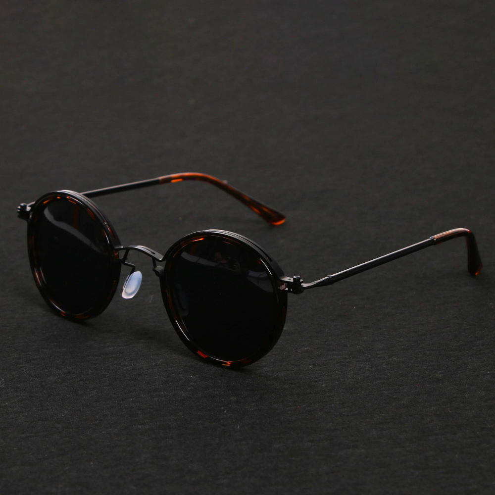 Round sunglasses with dark lenses on a dark gray background