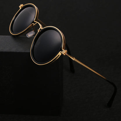 Gold-framed sunglasses with black lenses on a black background