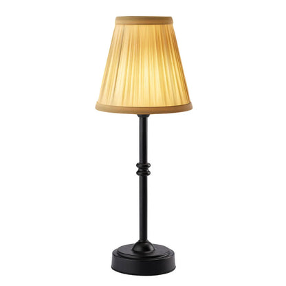 Table lamp with a gold shade and black base on a white background