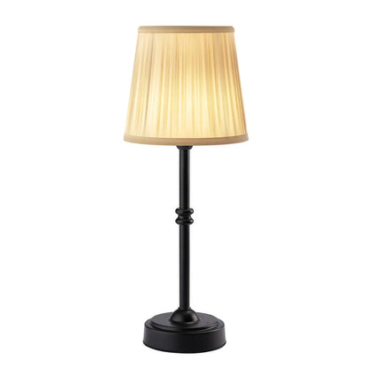 Table lamp with a beige shade and black base on a white background