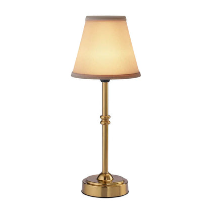 Table lamp with a gold base and beige shade on a white background