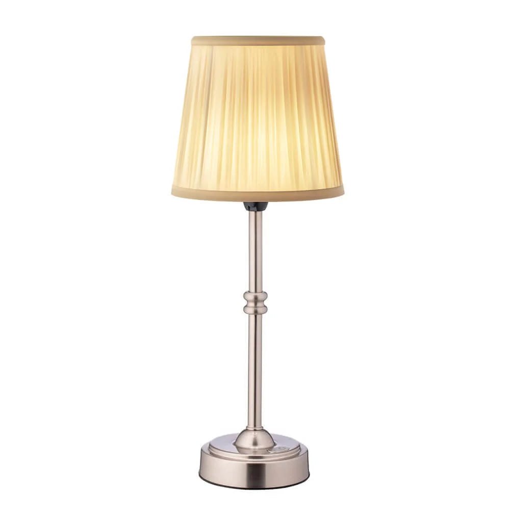 Table lamp with beige pleated shade and metallic base on a white background