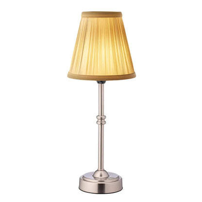 Table lamp with a gold shade and silver base on a white background