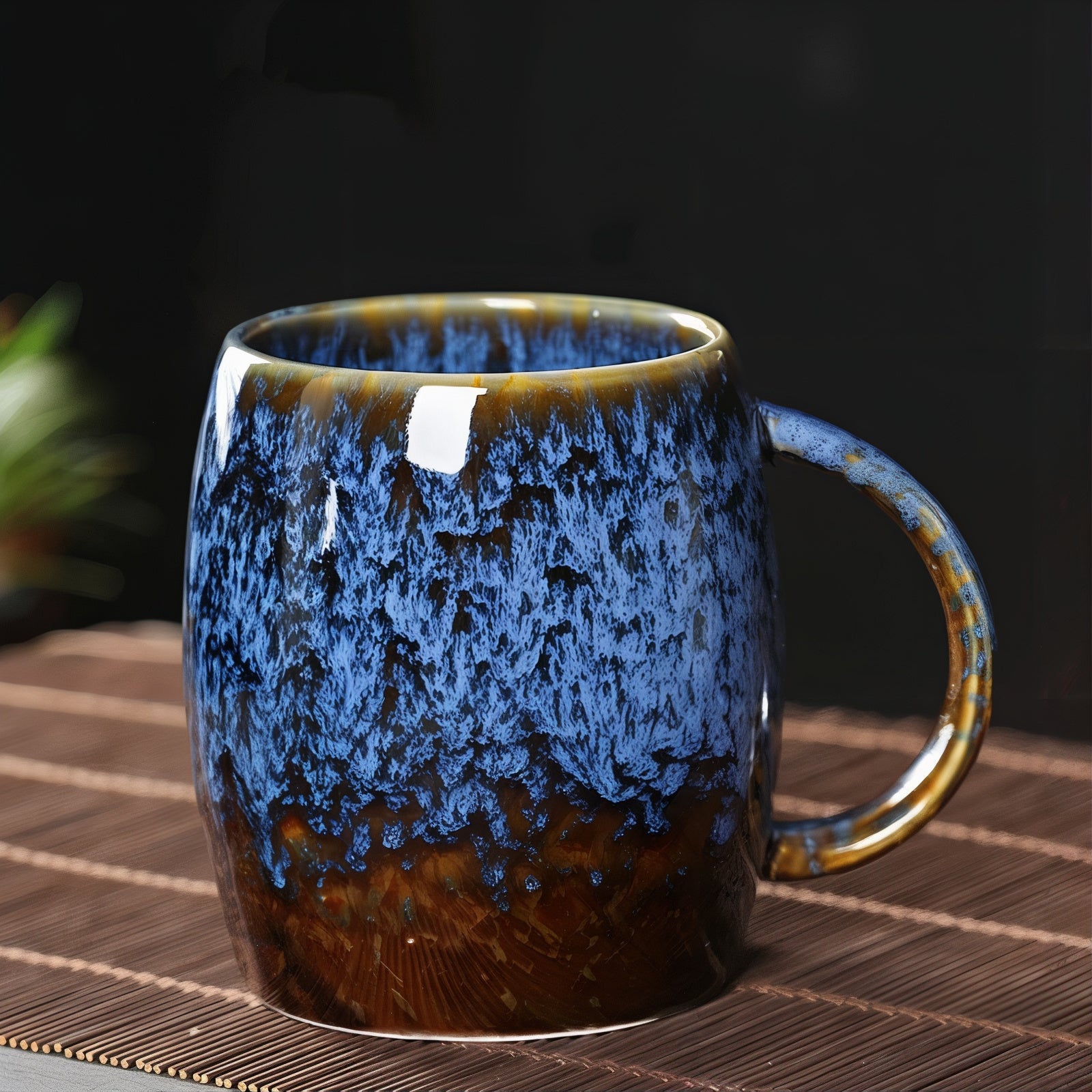 Blue and brown ceramic mug on a woven surface with a dark background