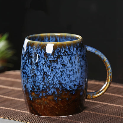 Blue and brown ceramic mug on a woven surface with a dark background