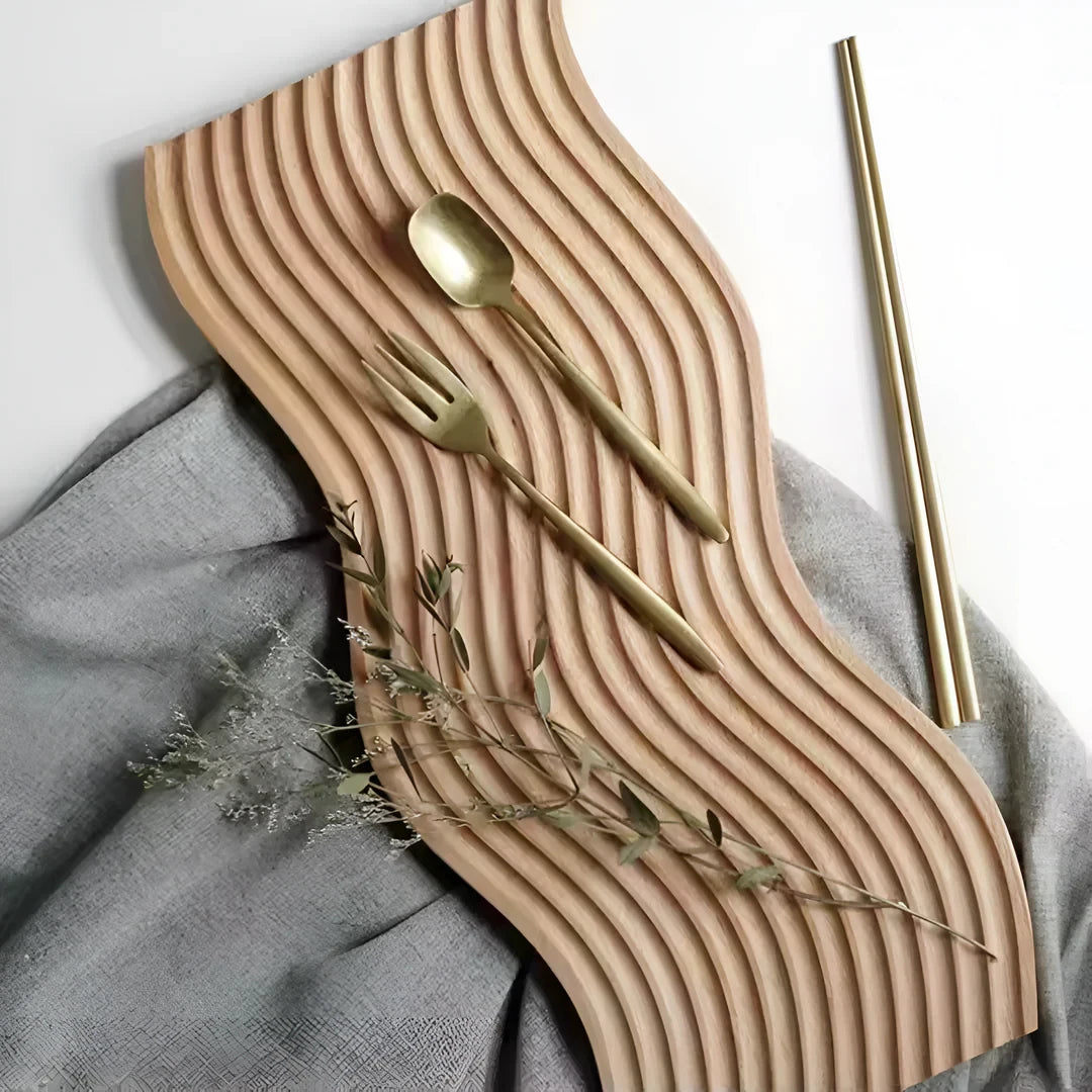 Josh & Tate - Ripple Wave Wooden Serving Tray - Wooden wavy placemat with gold cutlery on a gray fabric background