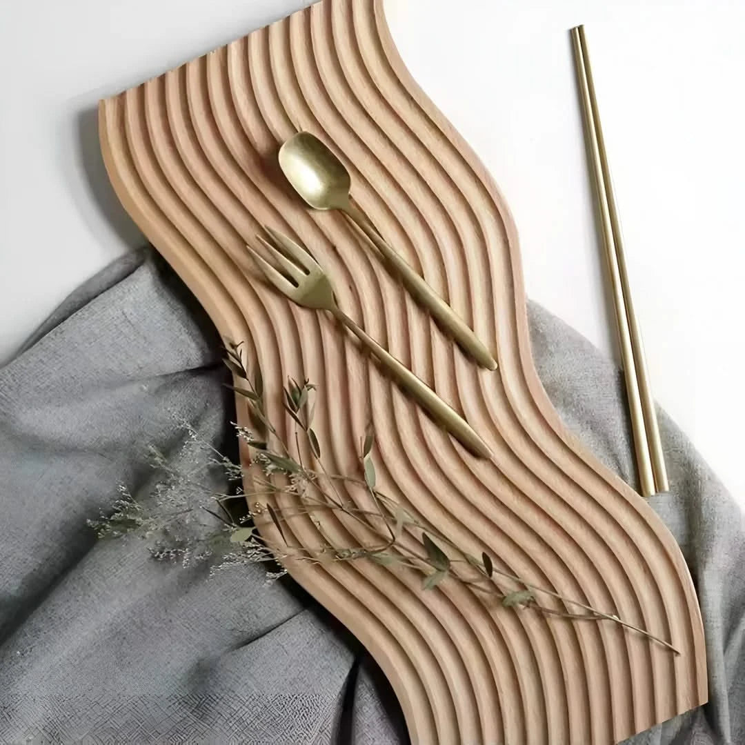 Josh & Tate - Ripple Wave Wooden Serving Tray - Wooden wavy placemat with gold cutlery on a gray fabric background