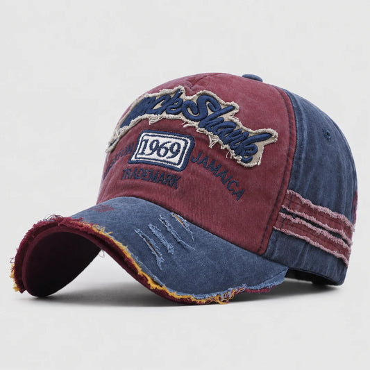 Josh & Tate - RockShank™ 1969 Baseball Cap - A distressed baseball cap with a split design featuring a washed burgundy front panel and a blue denim-look brim and side panels. The front features embroidered patches with 'JACKIE SHARKS', '1969', and 'JAMAICA' details.