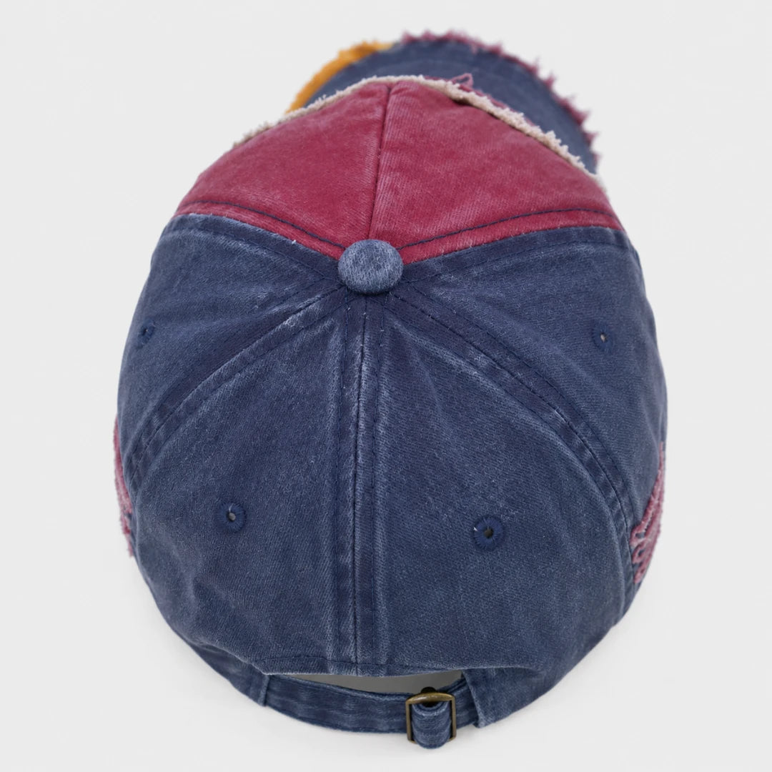 Josh & Tate - RockShank™ 1969 Baseball Cap - A distressed baseball cap viewed from the back, featuring a washed navy blue crown, a dusty rose red back panel, and a fuzzy orange inner lining.