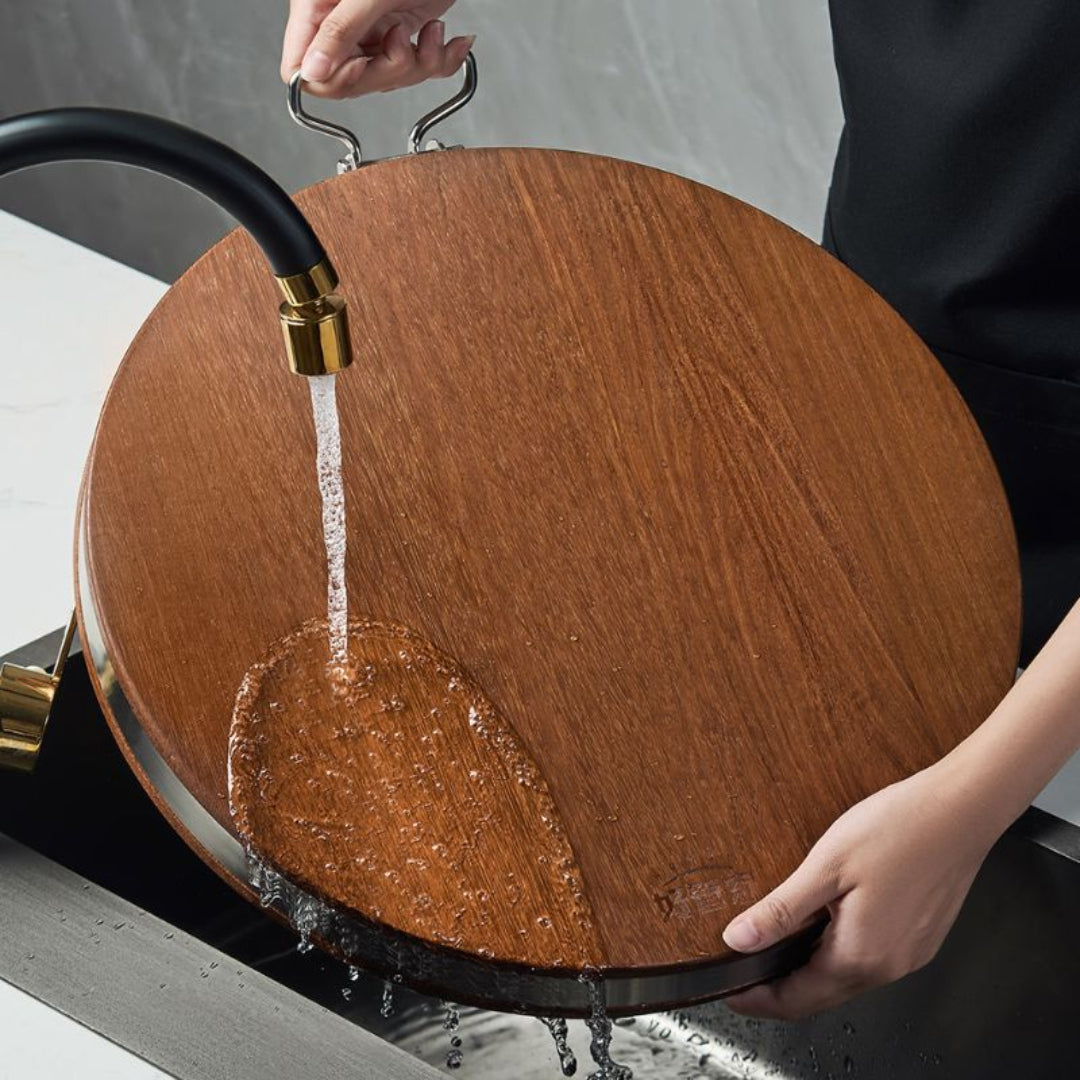 Wooden cutting board with water being poured onto it from a faucet.