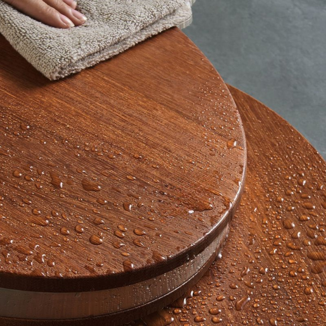 Wooden surface with water droplets being wiped by a cloth