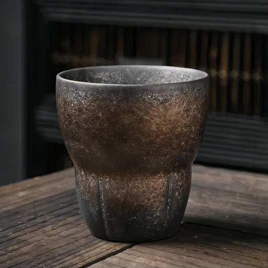 Textured ceramic cup on a wooden surface with a blurred background