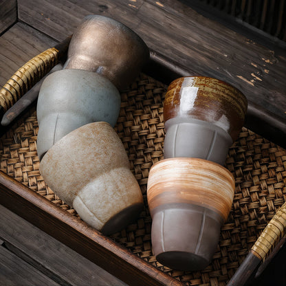 Set of ceramic cups with natural patterns on a woven surface
