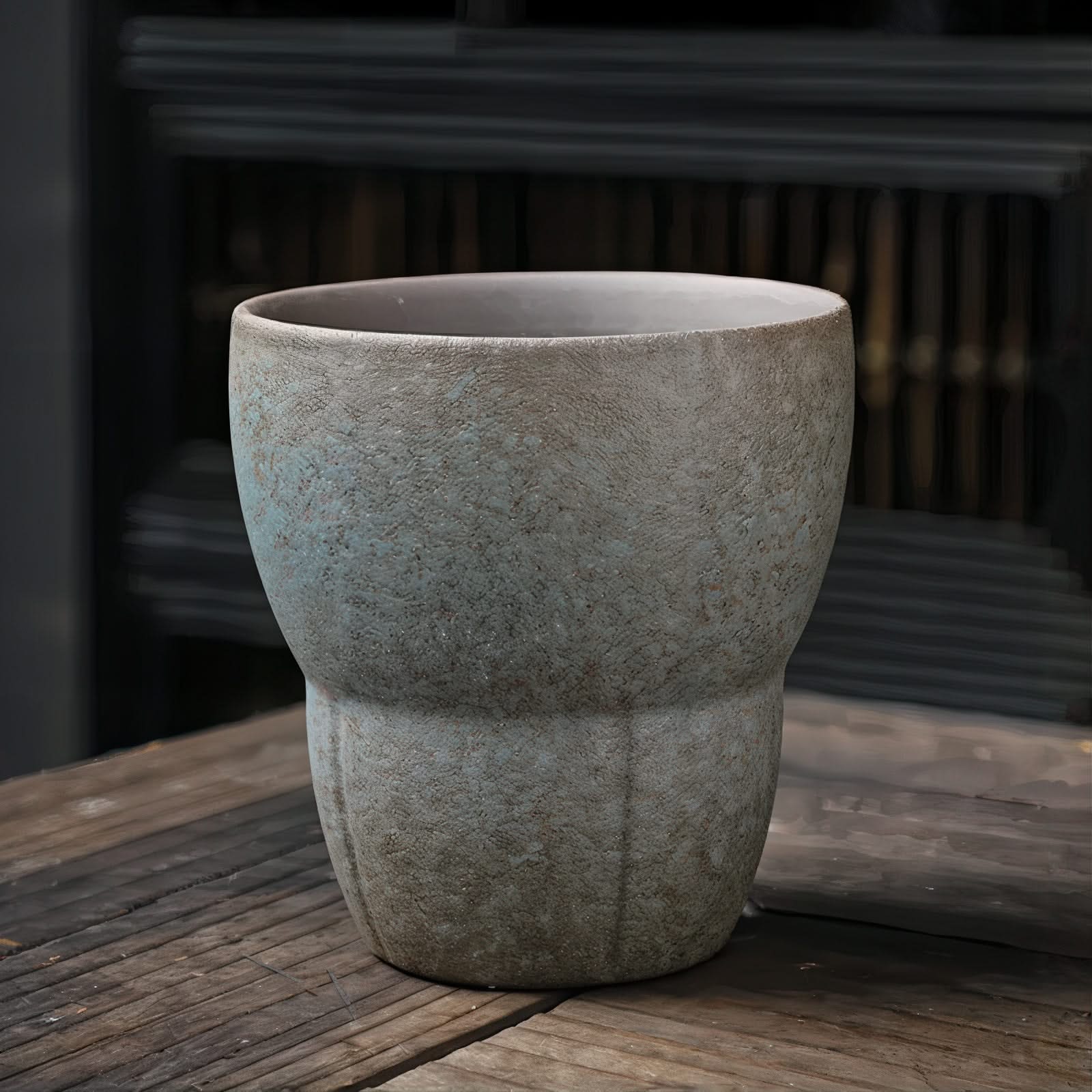 Gray stone planter on a wooden surface with a blurred background