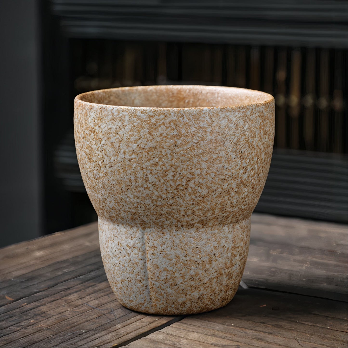 Textured ceramic pot on a wooden surface with a blurred background