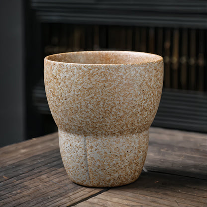 Textured ceramic pot on a wooden surface with a blurred background