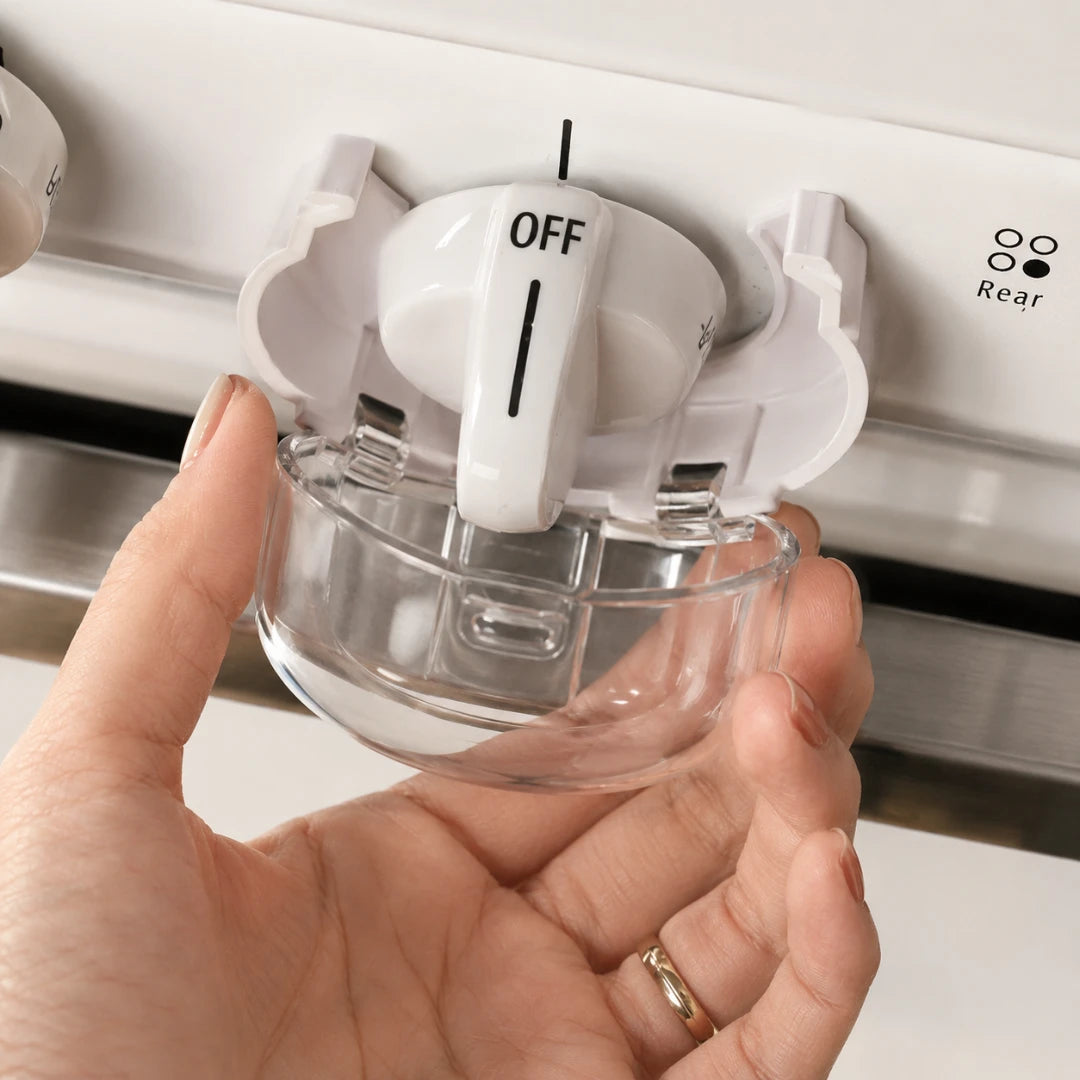 Josh & Tate - SafeKnob™ Child Safety Stove Covers - A hand holding a clear glass bowl under a white stove knob labeled OFF, with the stove control panel in the background.