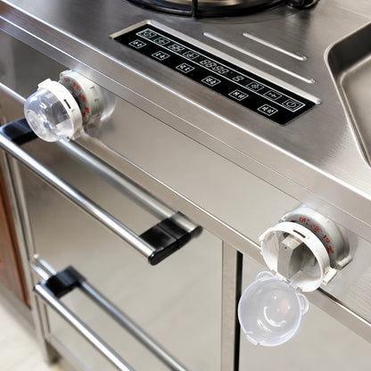 Josh & Tate - SafeKnob™ Child Safety Stove Covers - Close-up of a stainless steel kitchen appliance, likely a stove or oven control panel, with two clear plastic drip trays hanging below the knobs.
