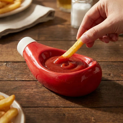 Josh & Tate - SaucePad™ Condiment Dip Tray - Hand dipping a french fry into a red ketchup container on a wooden table with fries and a glass in the background.