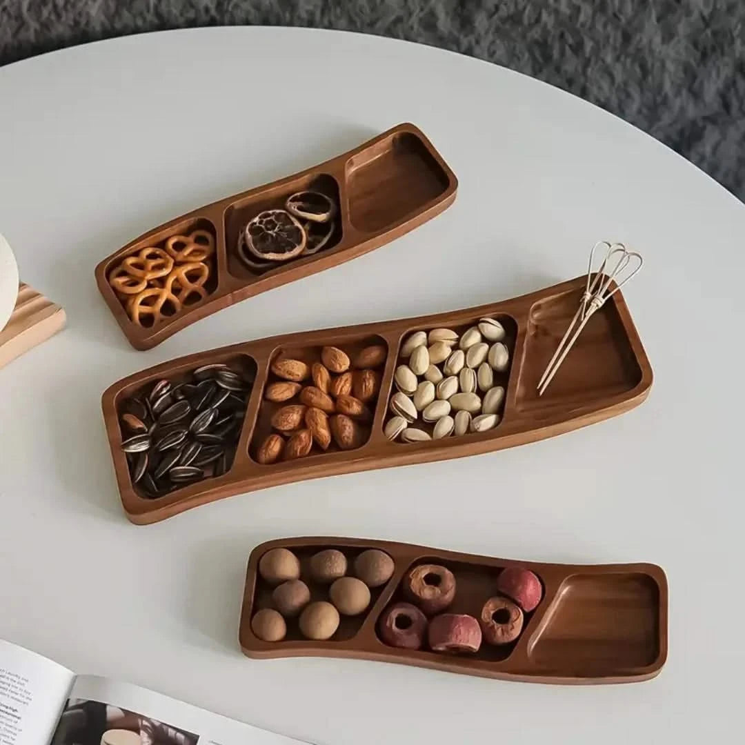 Josh & Tate - Sectioned Wooden Serving Tray - Wooden snack tray with compartments filled with various snacks on a white surface.