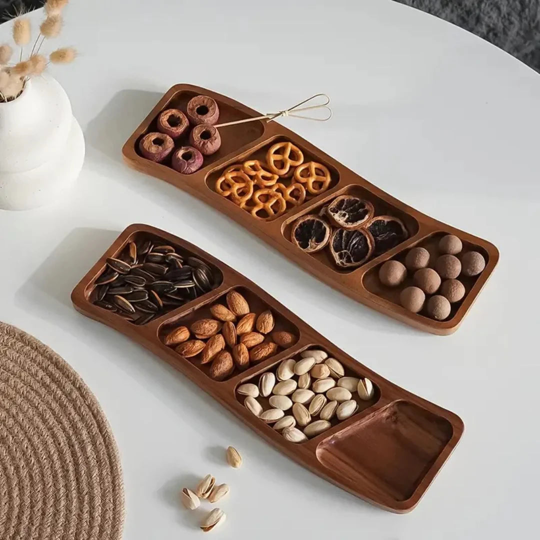 Josh & Tate - Sectioned Wooden Serving Tray - Wooden snack tray with compartments filled with various snacks on a white surface.