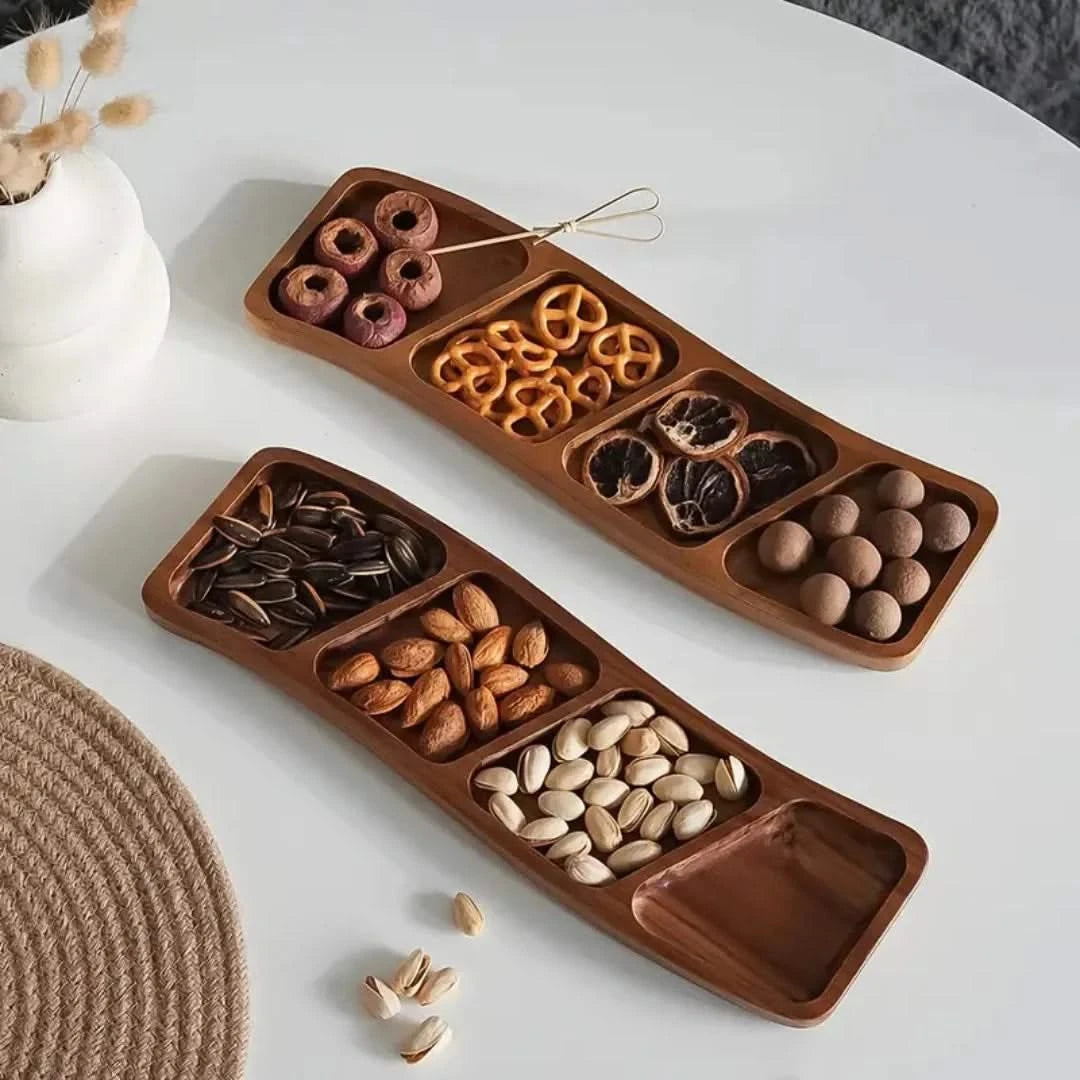 Josh & Tate - Sectioned Wooden Serving Tray - Wooden snack tray with compartments filled with various snacks on a white surface.